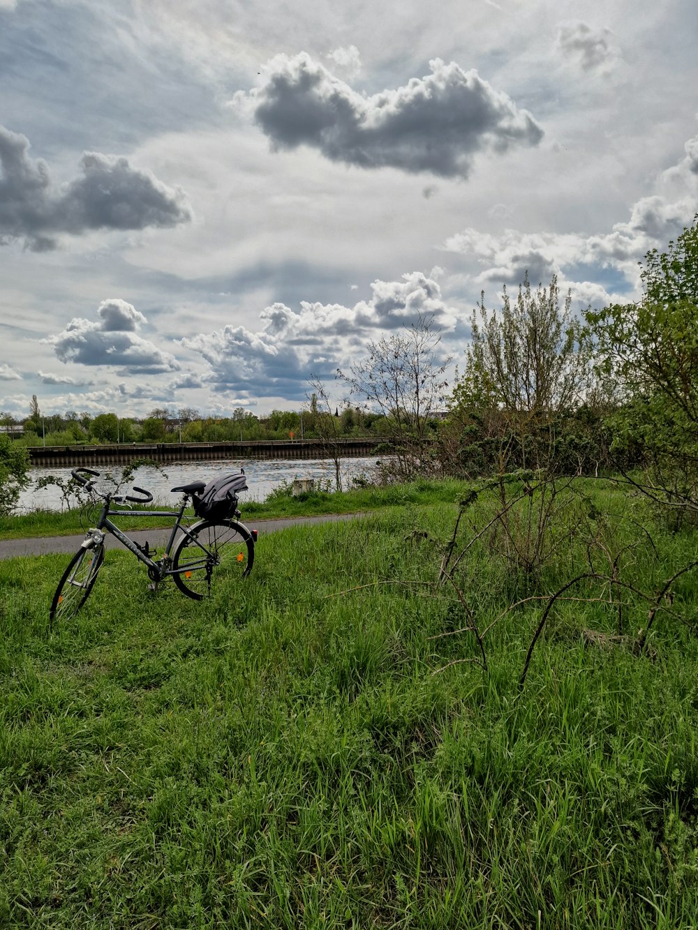 a bike parked on the side of a road next to a river