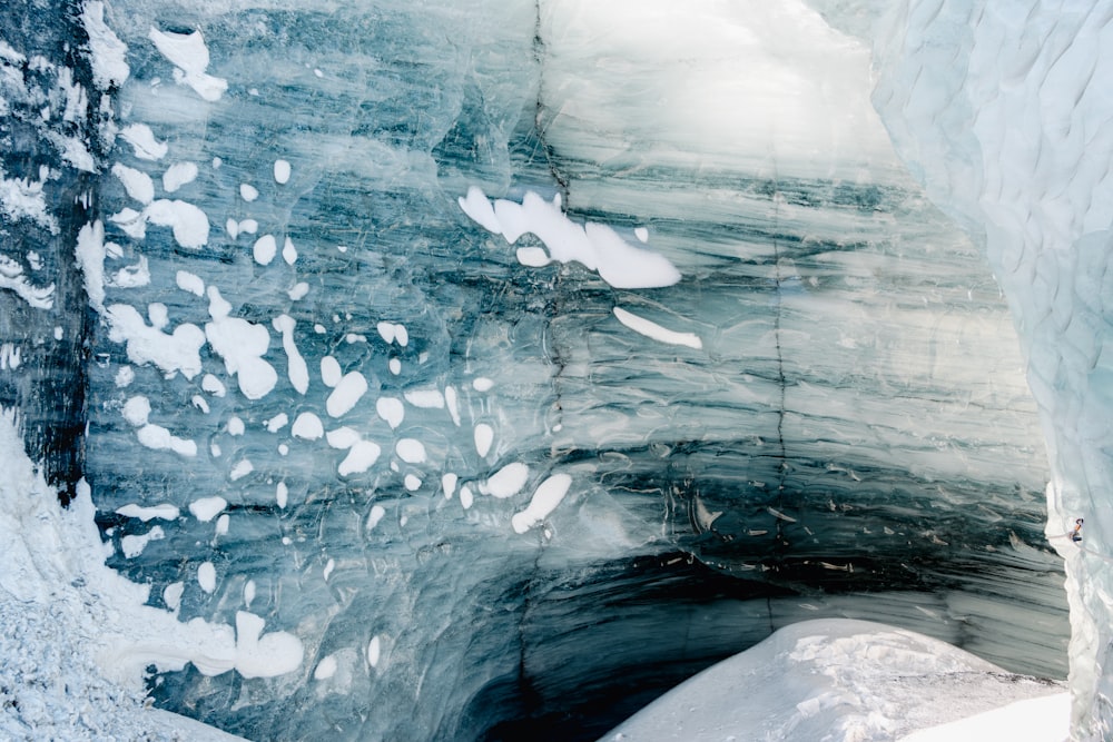 a large ice cave with snow on the ground