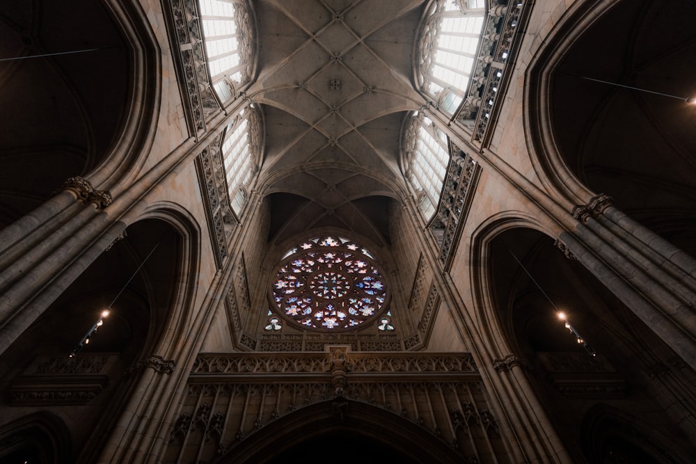 the ceiling of a cathedral with a large stained glass window