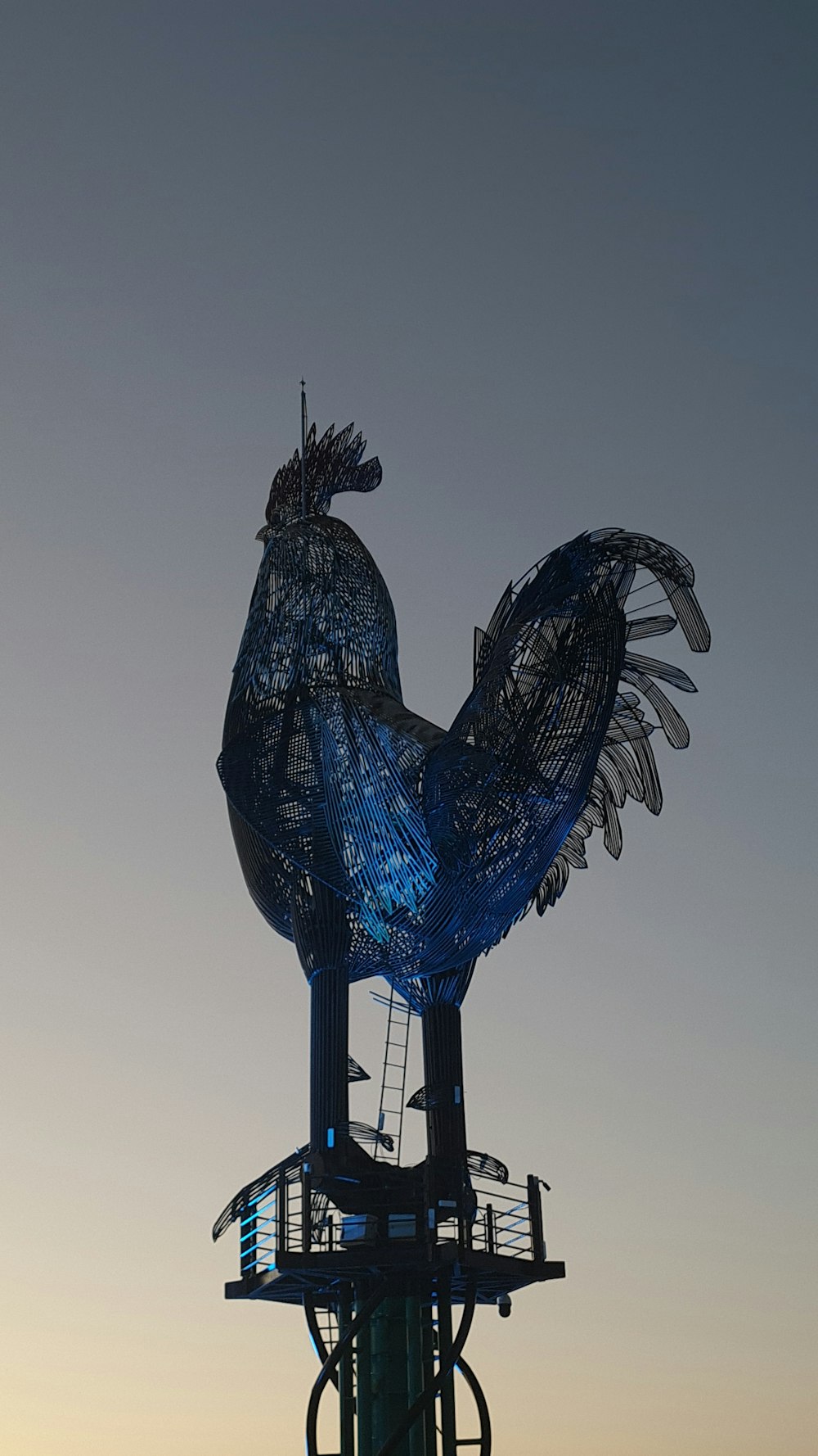 a large blue bird statue on top of a building