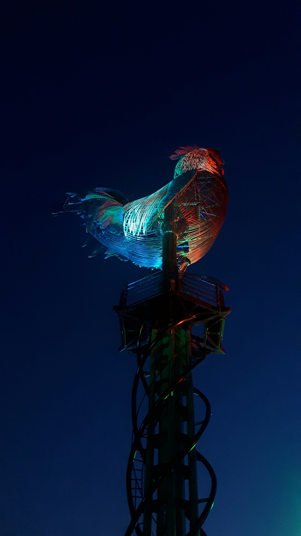 a colorful bird sitting on top of a tower