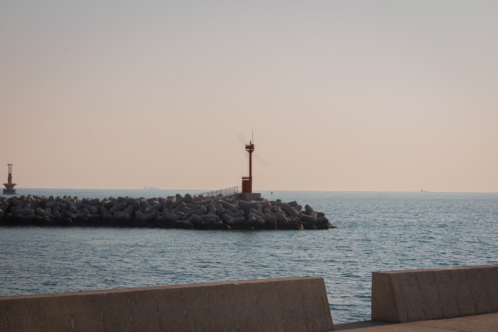 Ein Leuchtturm, der auf einem Pier neben dem Meer sitzt