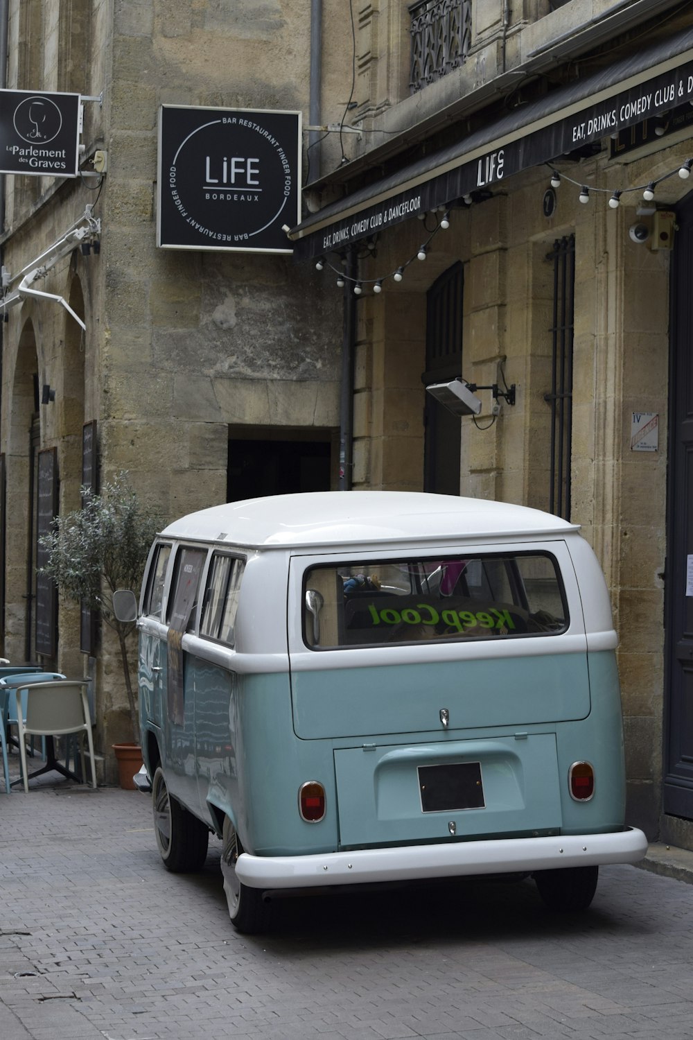 a blue and white van parked in front of a building