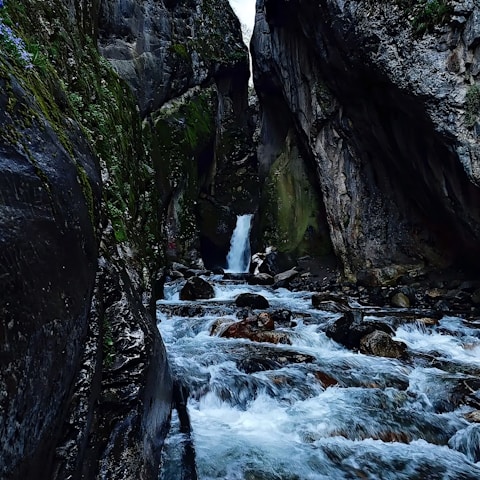 a small waterfall in the middle of a canyon