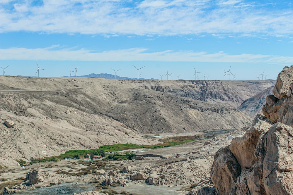 a view of a valley with wind mills in the distance