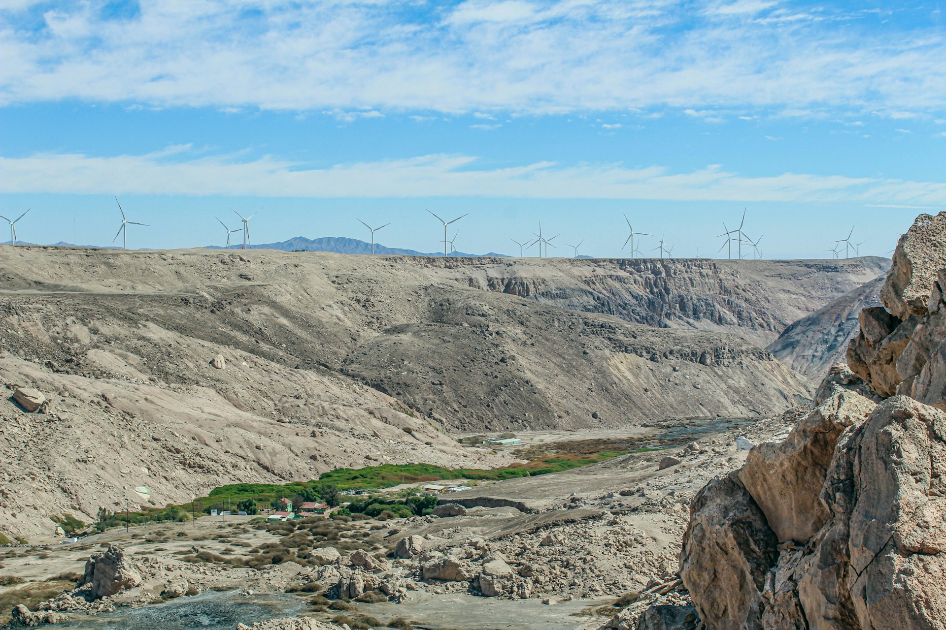 a view of a valley with wind mills in the distance