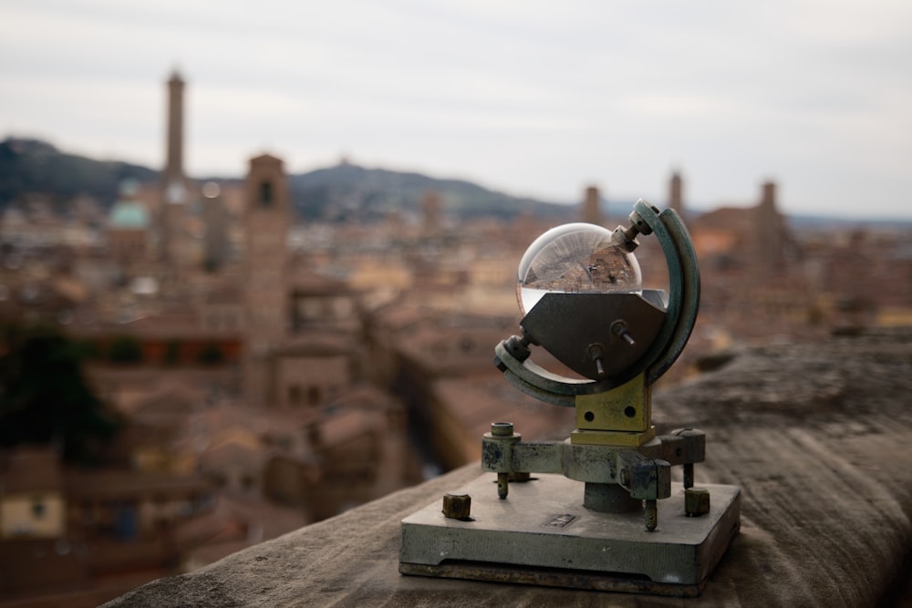 a telescope on top of a building with a city in the background