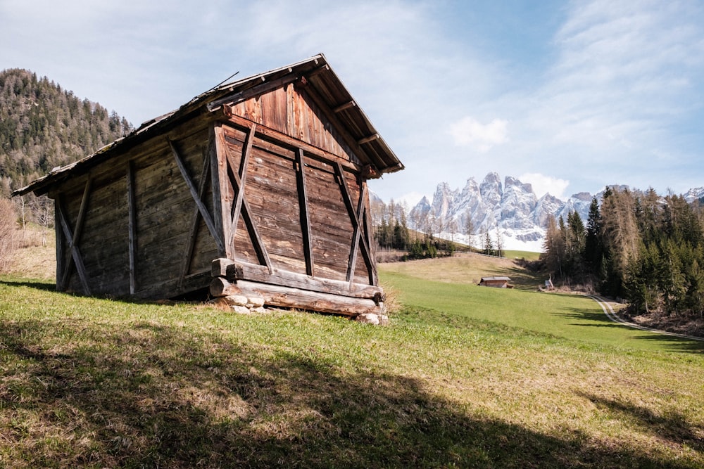 a small wooden cabin sitting on top of a lush green hillside