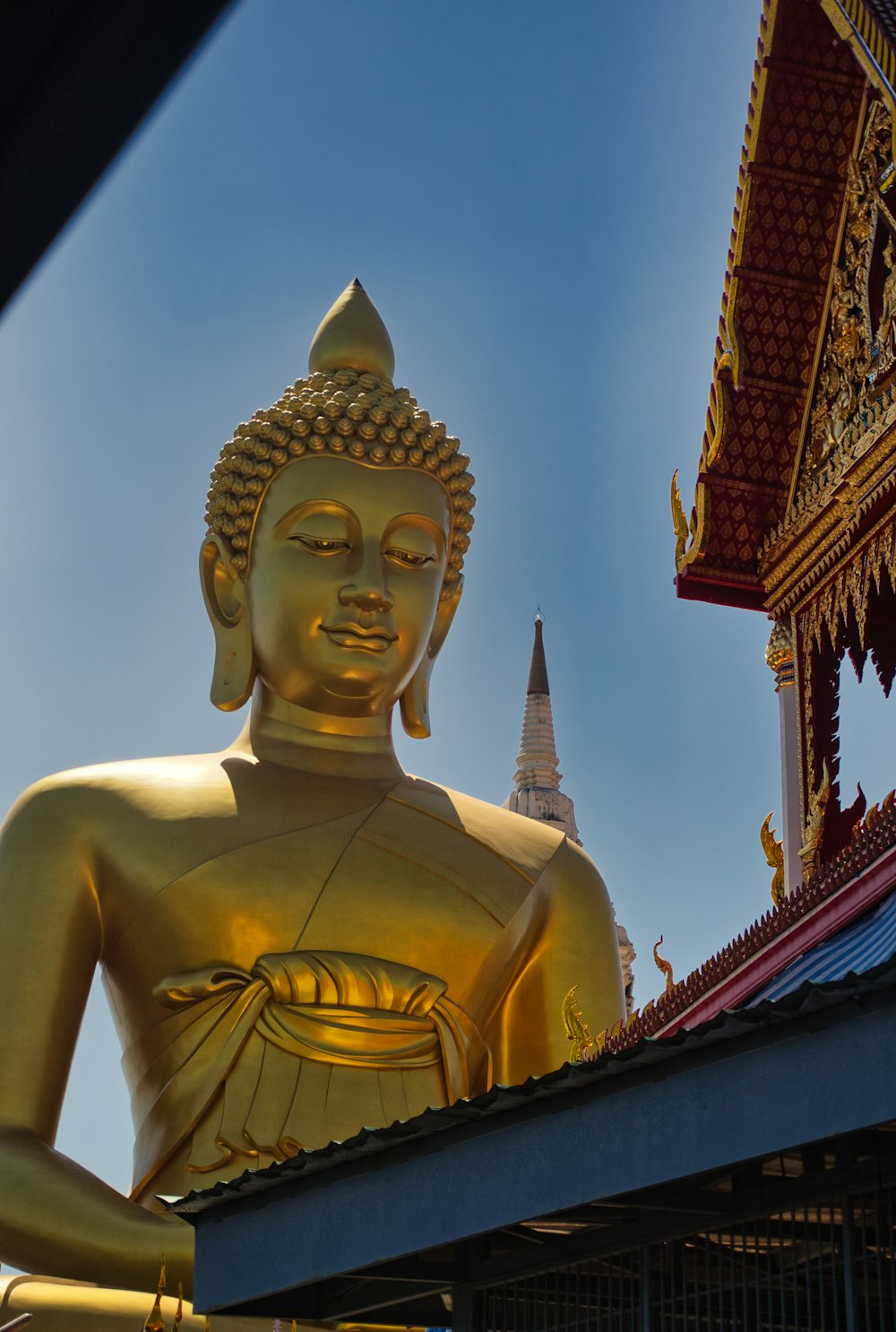 a golden buddha statue sitting on top of a roof