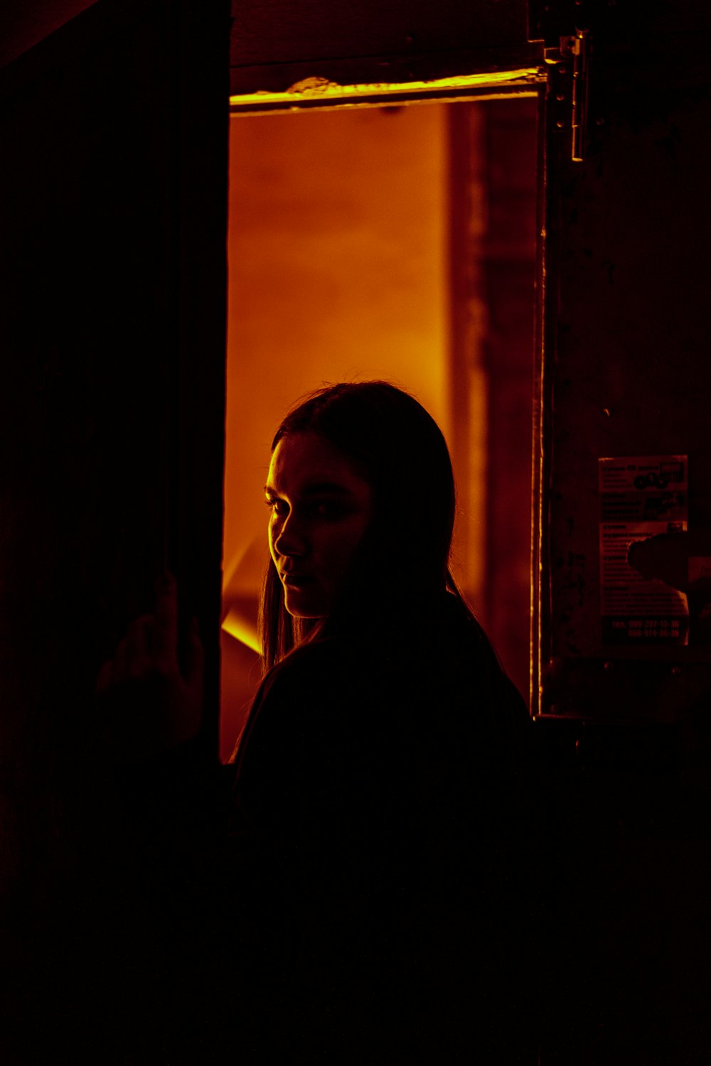 a woman standing in a doorway at night