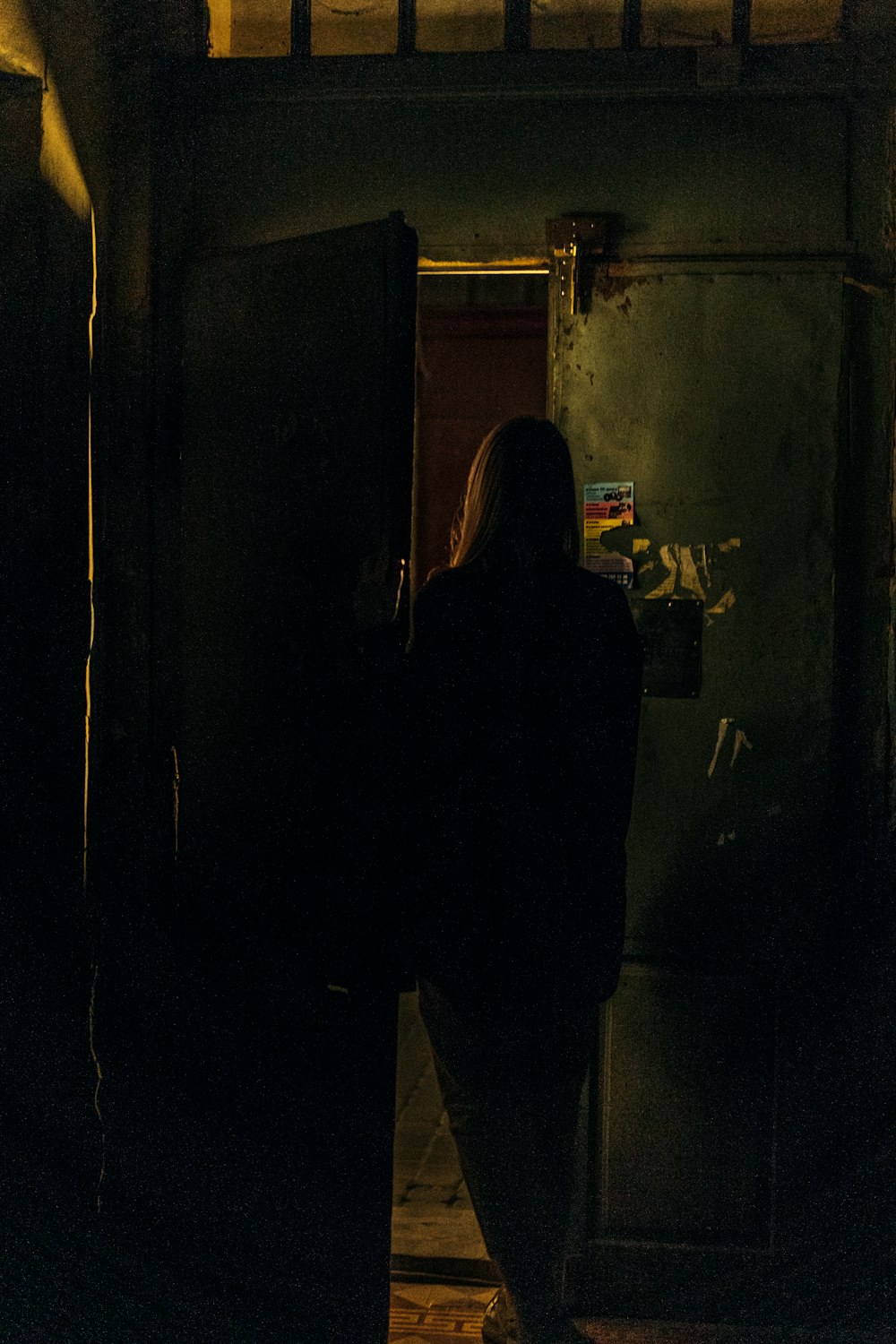 a woman standing in a doorway at night