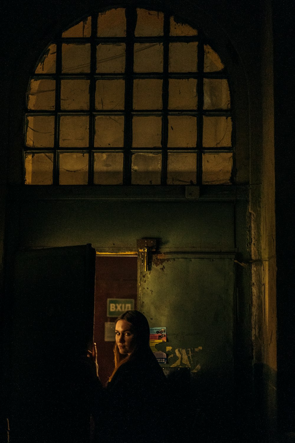 a woman standing in a doorway with a cell phone in her hand