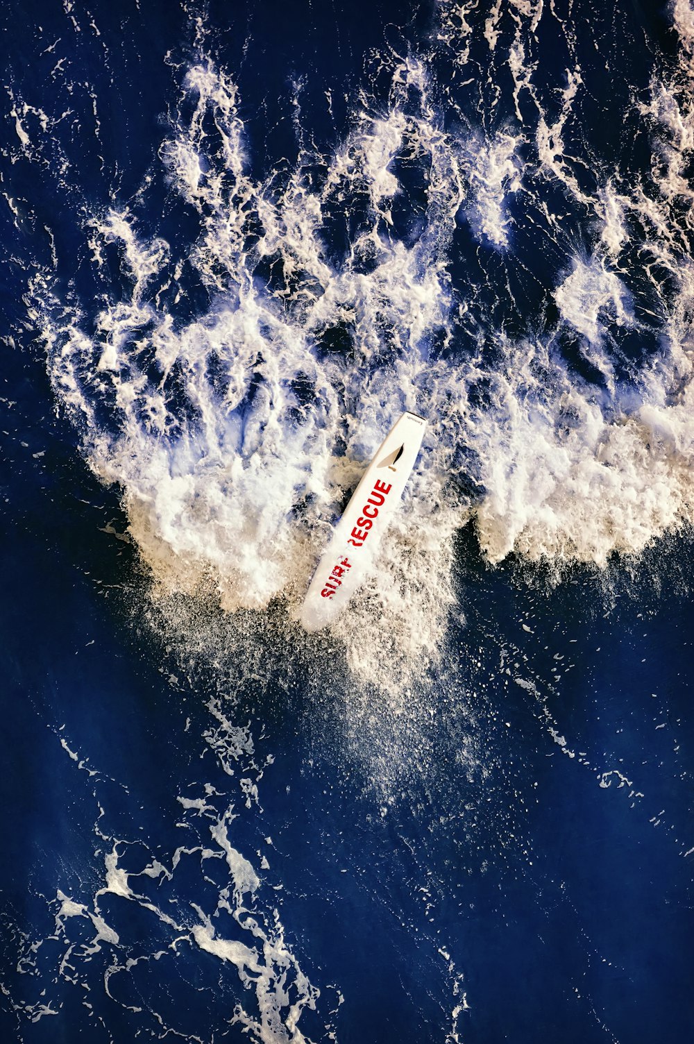 a white surfboard in the middle of the ocean