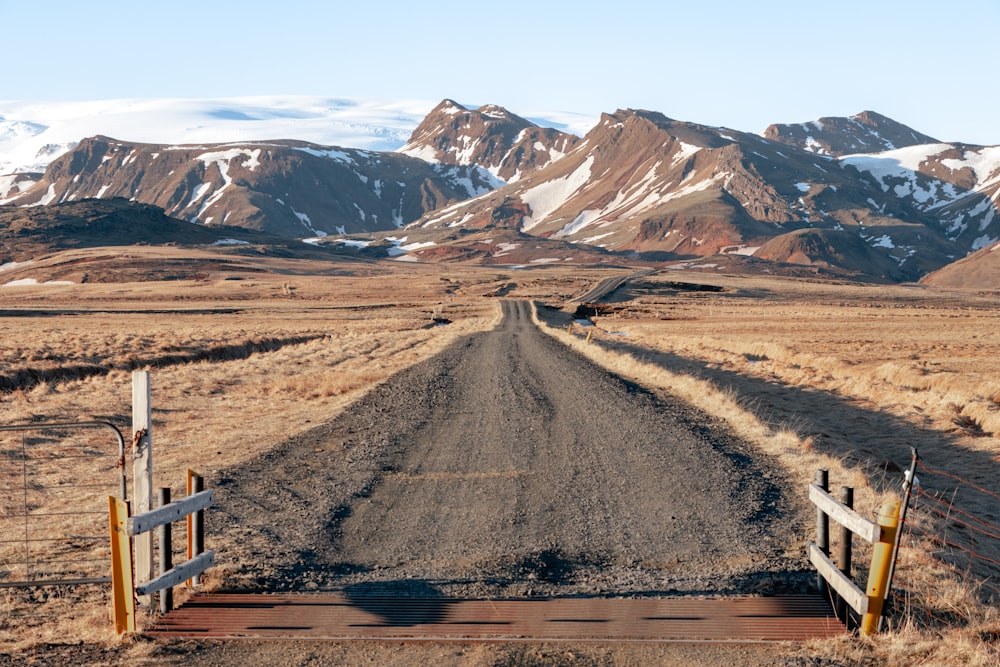 a dirt road with mountains in the background