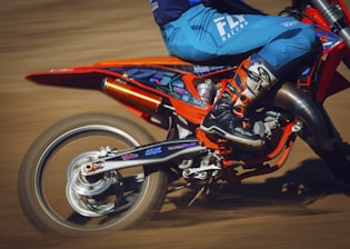 A close-up of a motorcycle's wheel kicking up dirt on a rugged trail, symbolizing excitement and freedom.