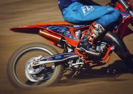 Dynamic shot of a motorcycle equipped with carbon fiber fairing speeding on a track.