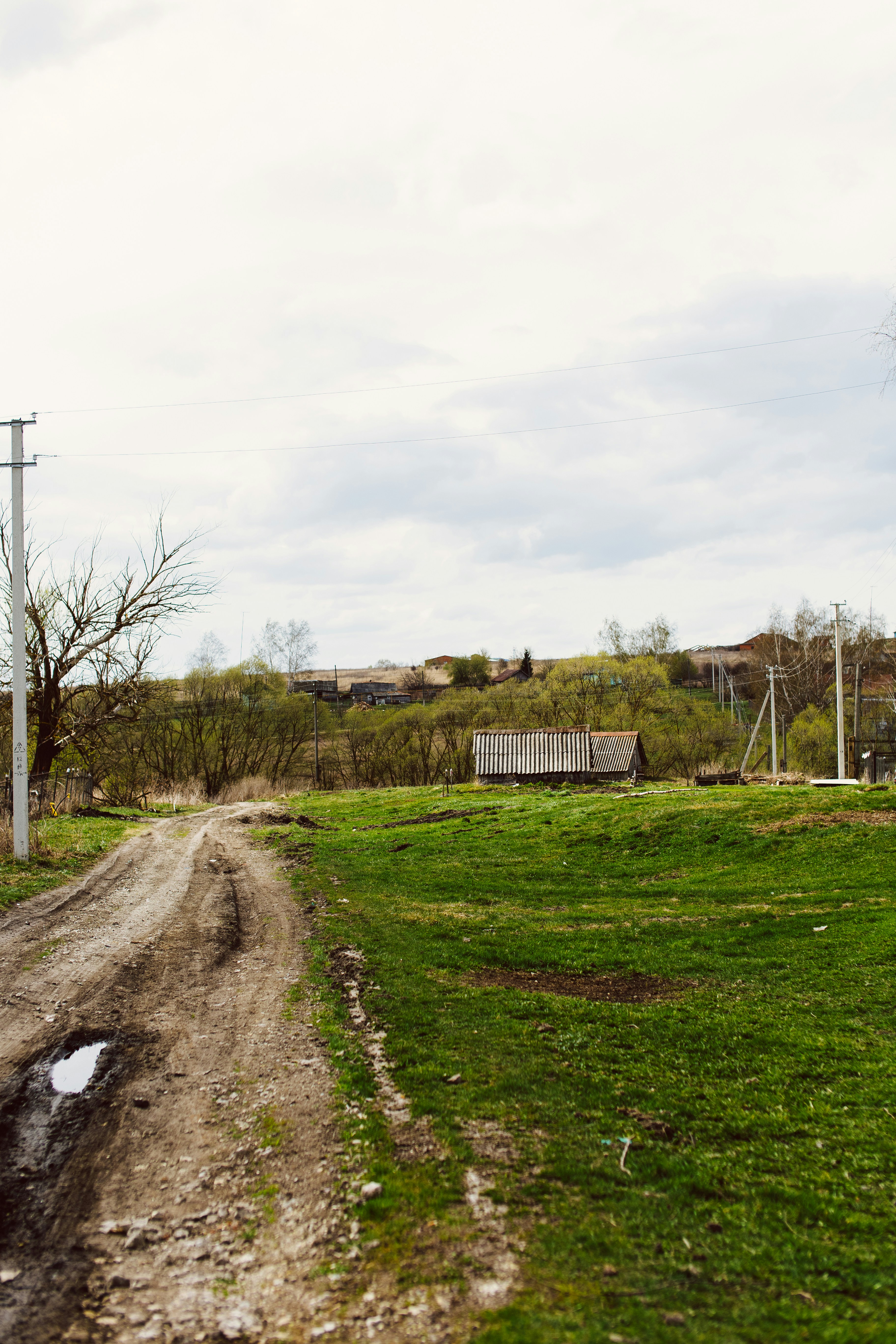 a dirt road with a bench in the distance