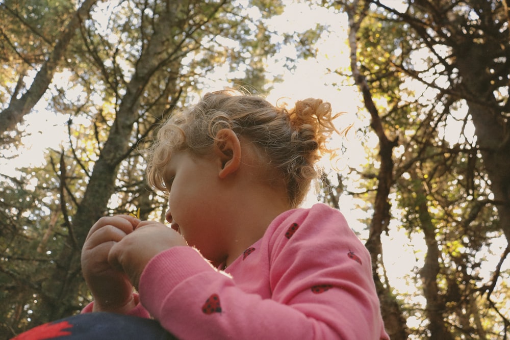 숲에 앉아 무언가를 먹고 있는 어린 소녀