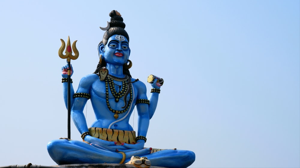 a statue of a hindu god holding a staff