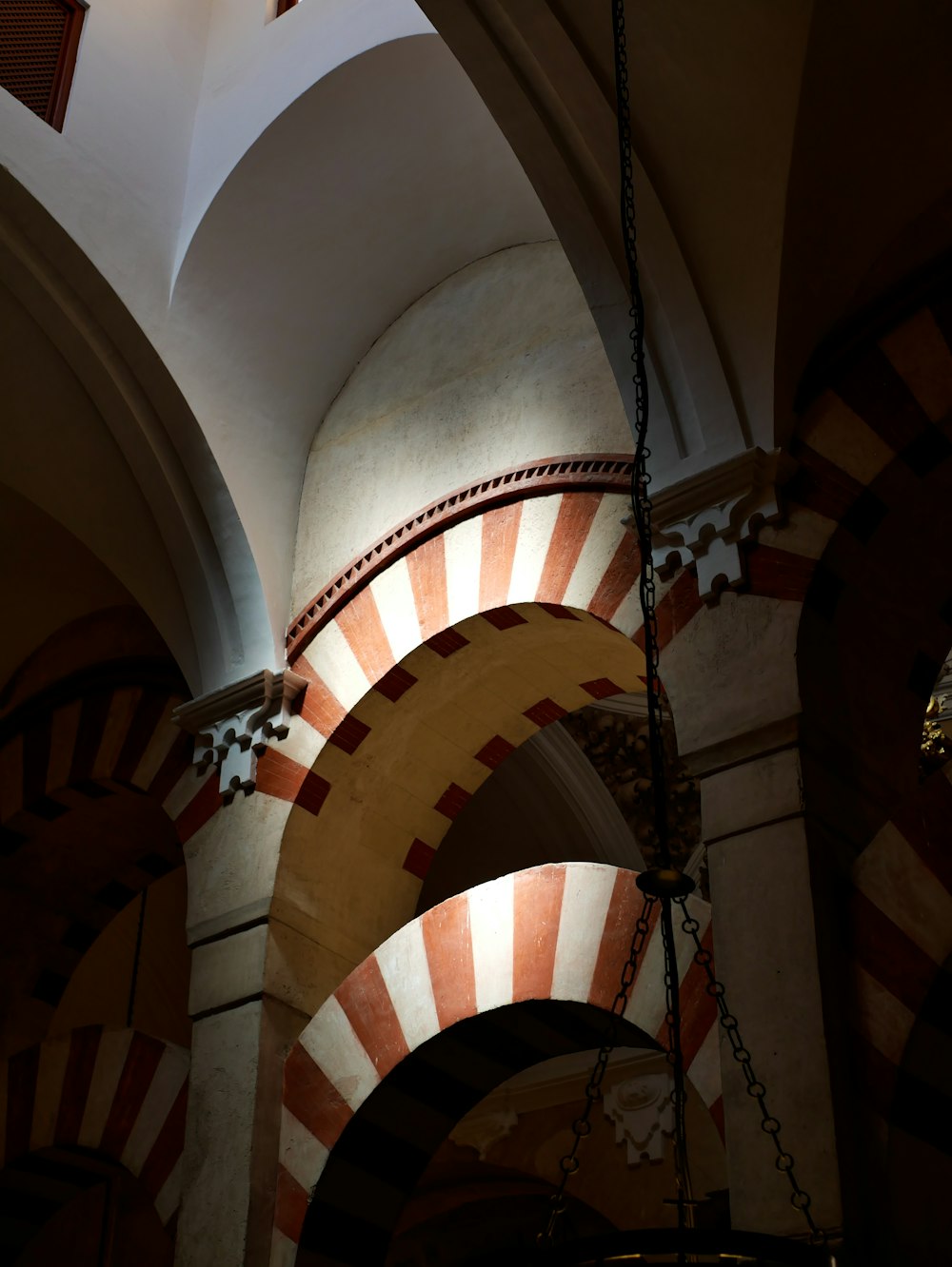 a clock hanging from the ceiling of a building