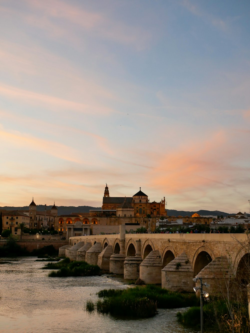 a bridge over a river with a castle in the background