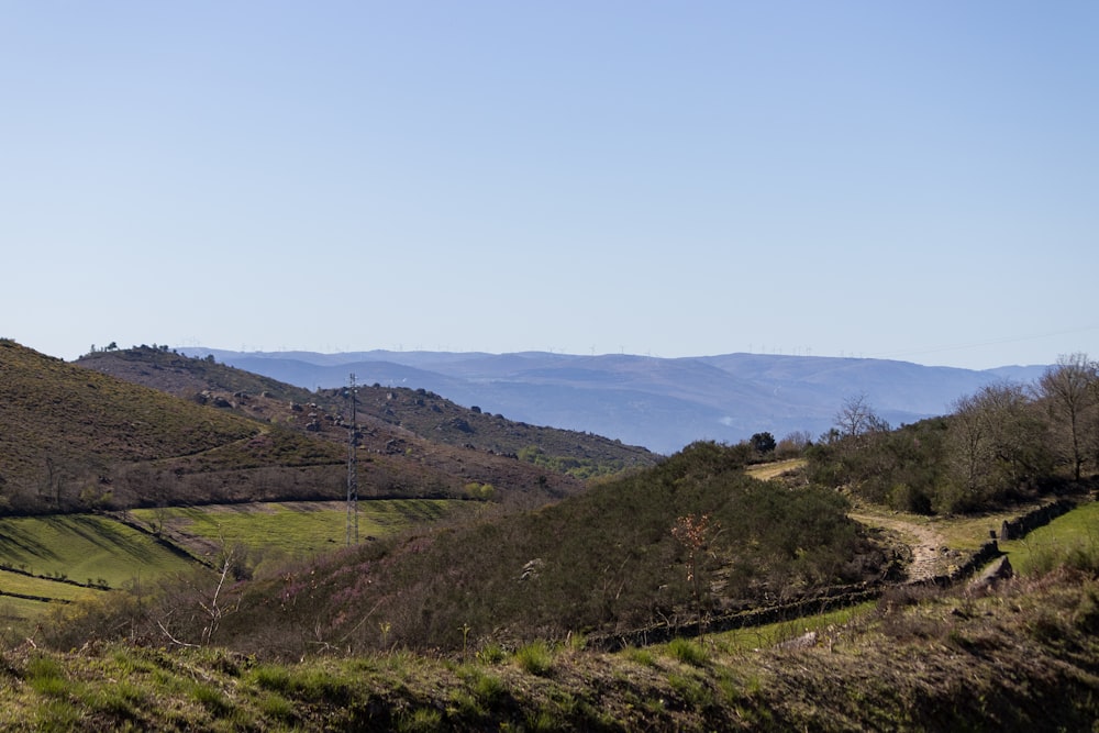 a scenic view of a hilly area with mountains in the background