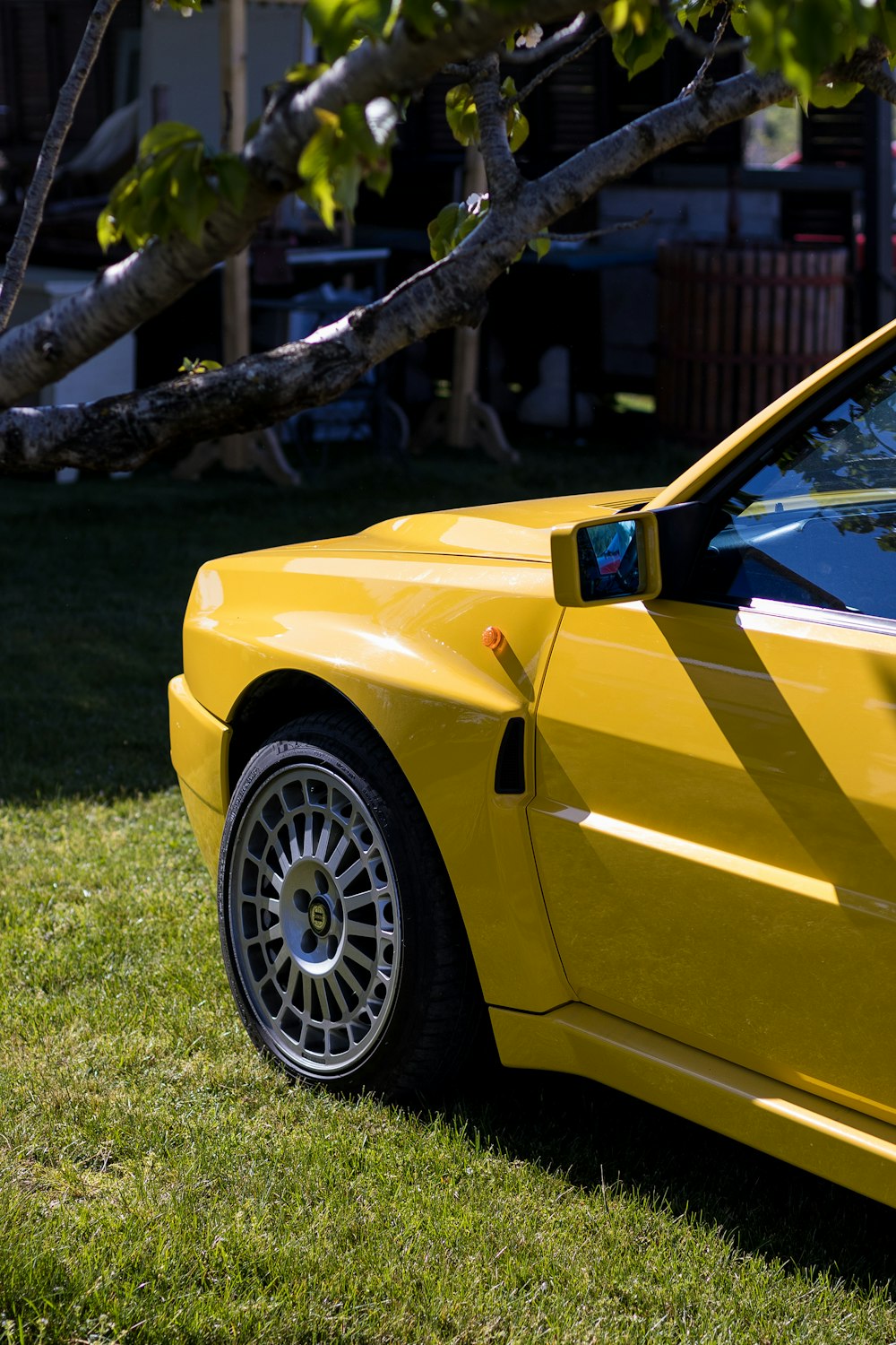 a yellow sports car parked in the grass