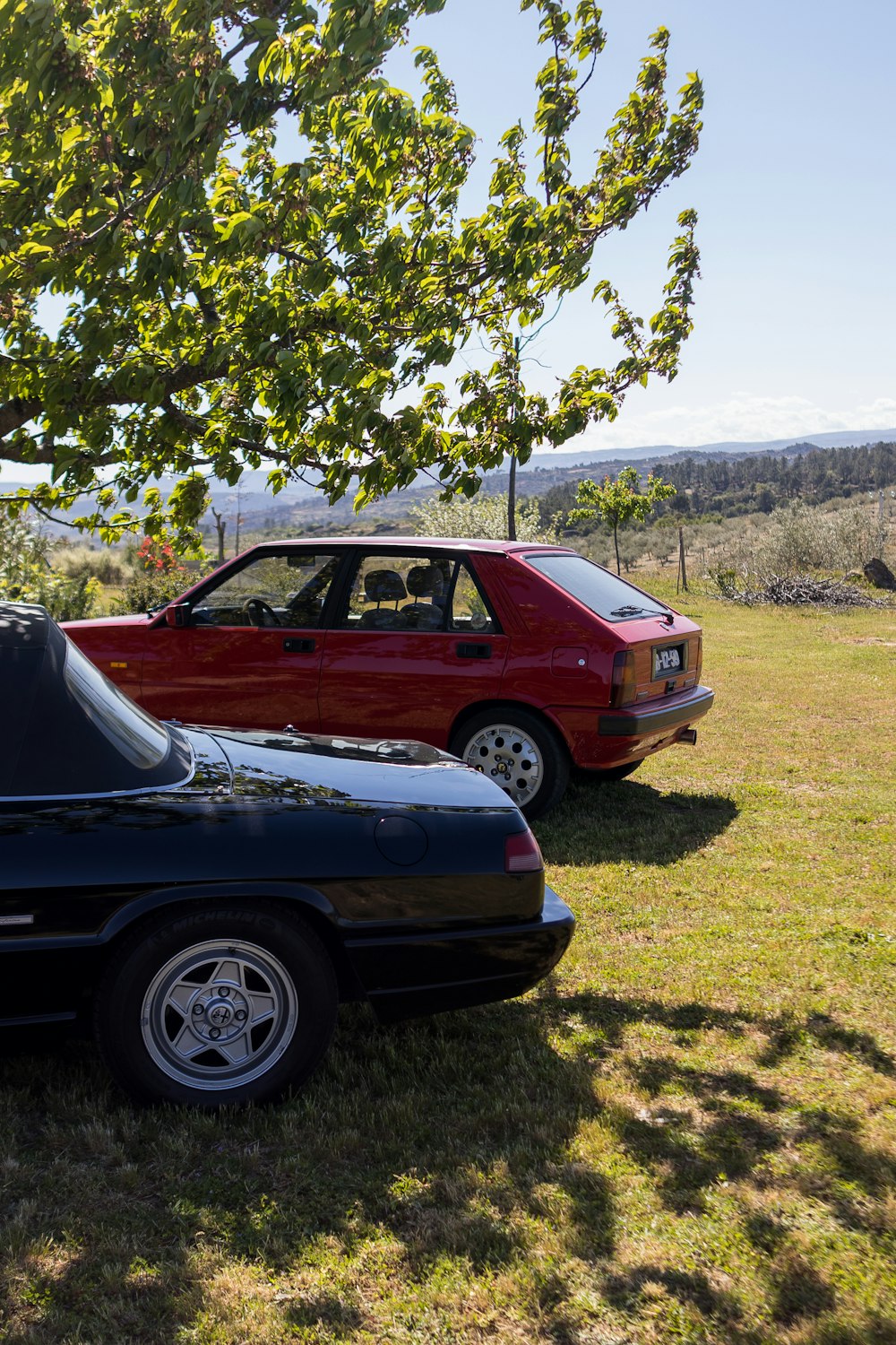 a couple of cars parked next to each other in a field