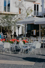 An outdoor café table with a sturdy metal base and weather-resistant surface.