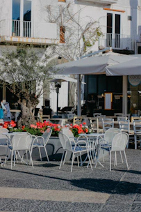 An outdoor café table with a sturdy metal base and weather-resistant surface.