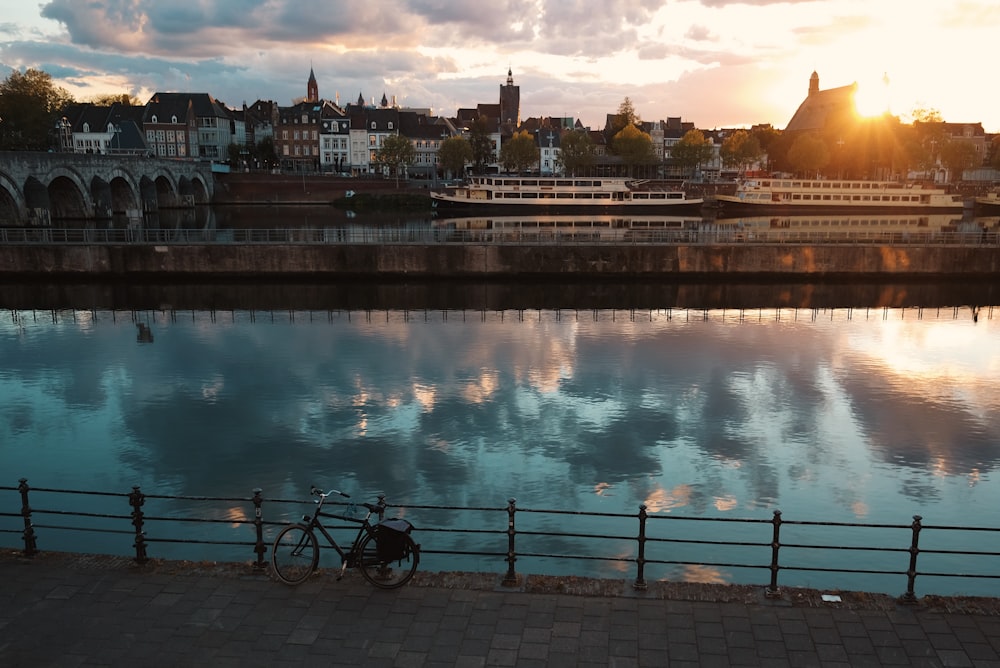 a bike parked next to a fence near a body of water