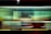 A blurred motion capture of a moving subway or train, characterized by streaks of light and color that create a sense of speed and dynamism. The image features a blend of green, yellow, and red hues with black background elements, conveying the fast-paced urban environment.