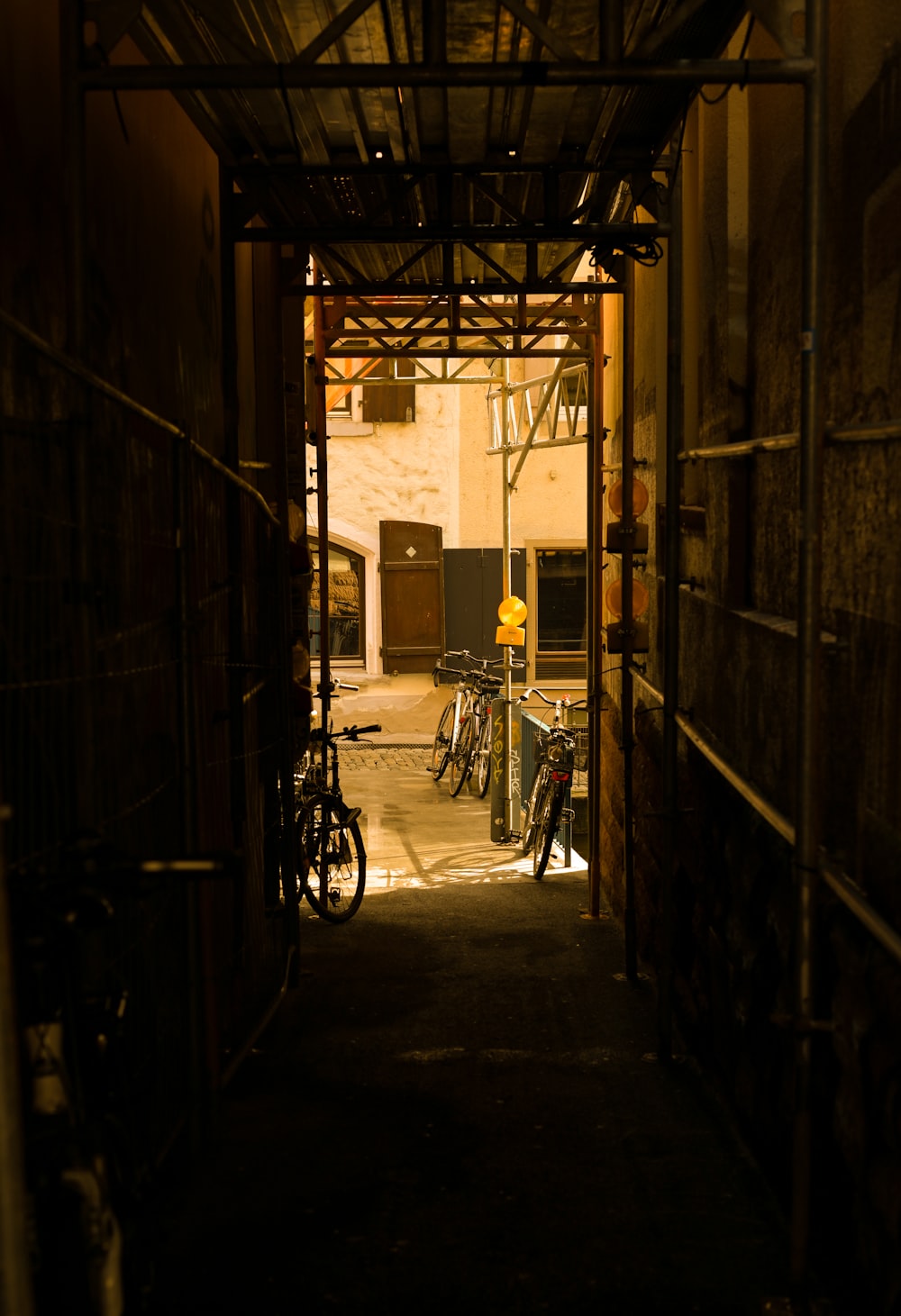 a dark alley with bicycles parked in it
