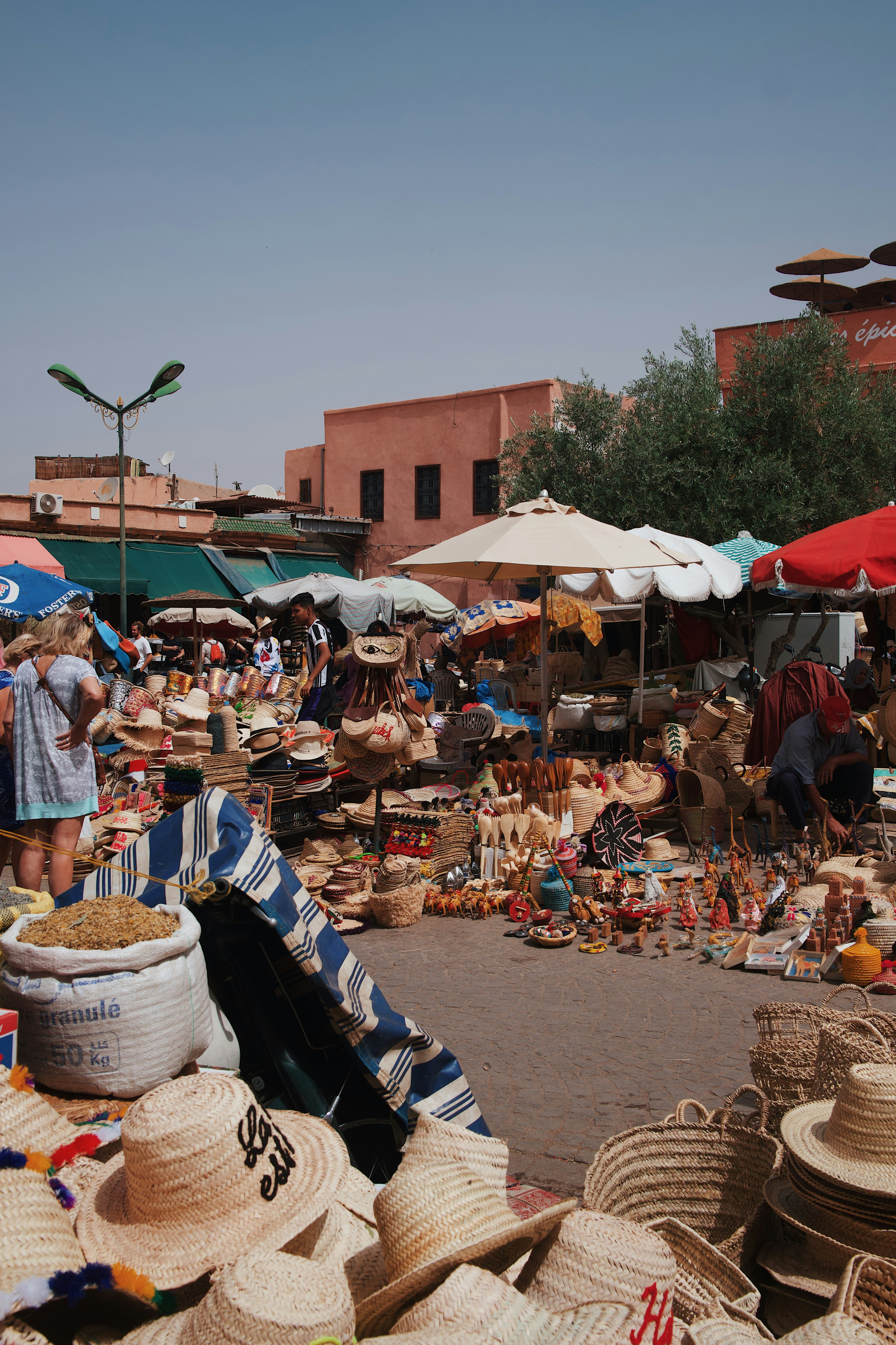 a woman standing in front of a pile of hats