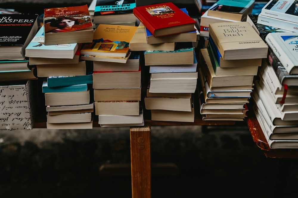 a pile of books sitting on top of a wooden table