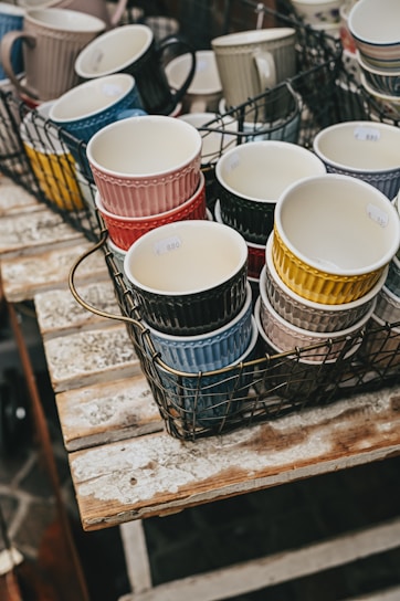 Colorful ceramic mugs arranged on a wooden table