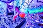a woman mixing music in a colorful room