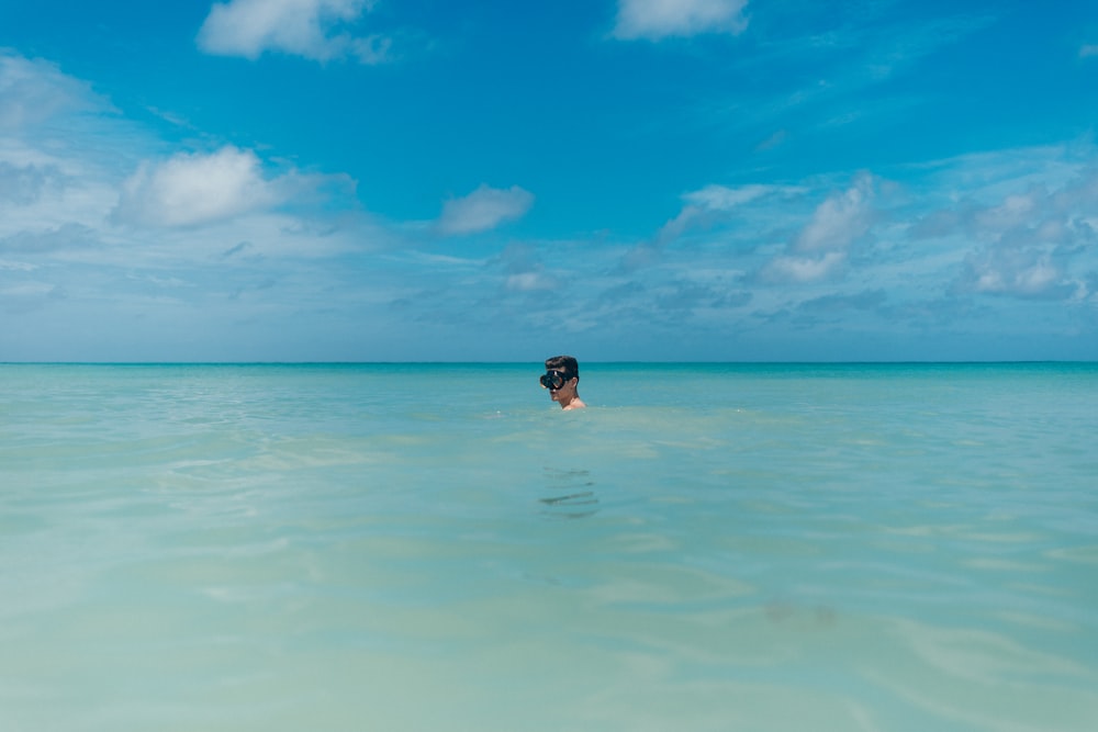 a woman swimming in the ocean on a sunny day