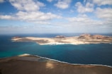 A scenic aerial shot of a tropical island surrounded by clear blue water.