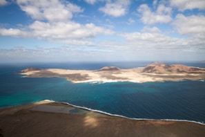 A scenic aerial shot of a tropical island surrounded by clear blue water.