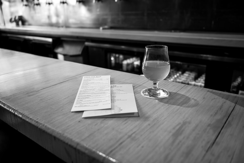 a glass of wine sitting on top of a wooden table