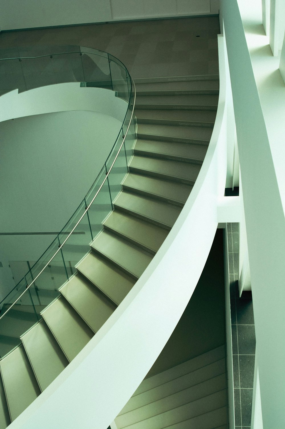 a spiral staircase in a building with glass railings