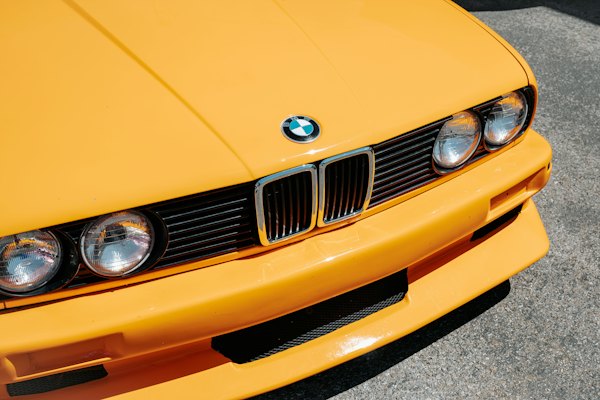 A close up of the front of a yellow car