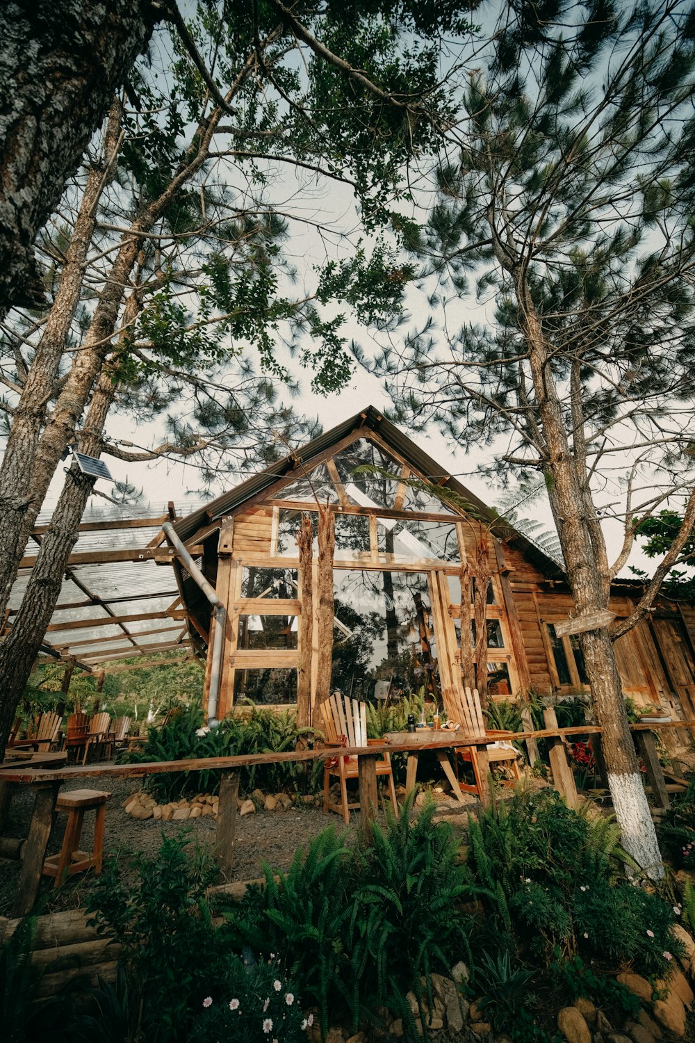 a wooden house surrounded by trees and plants