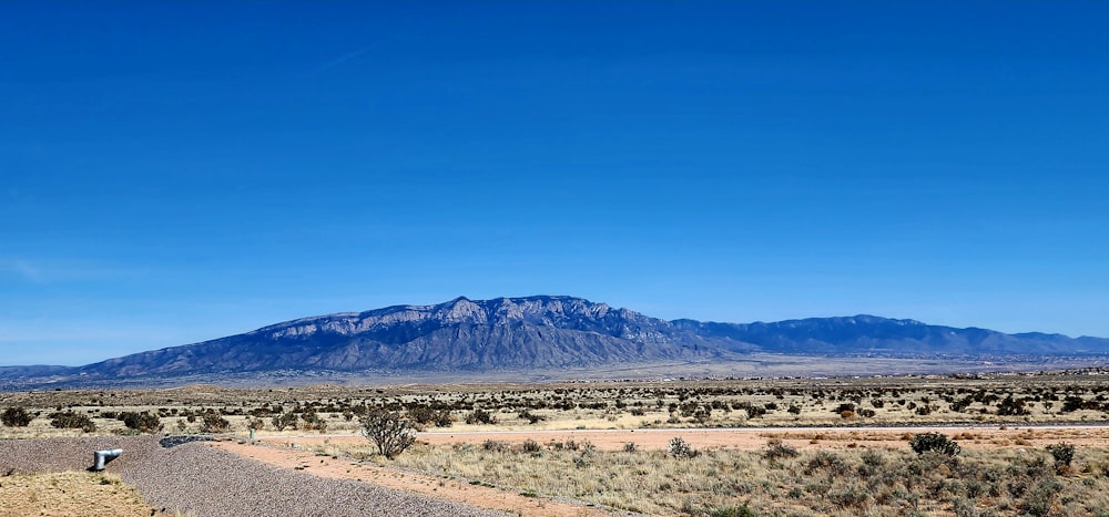 a dirt road with a mountain in the background