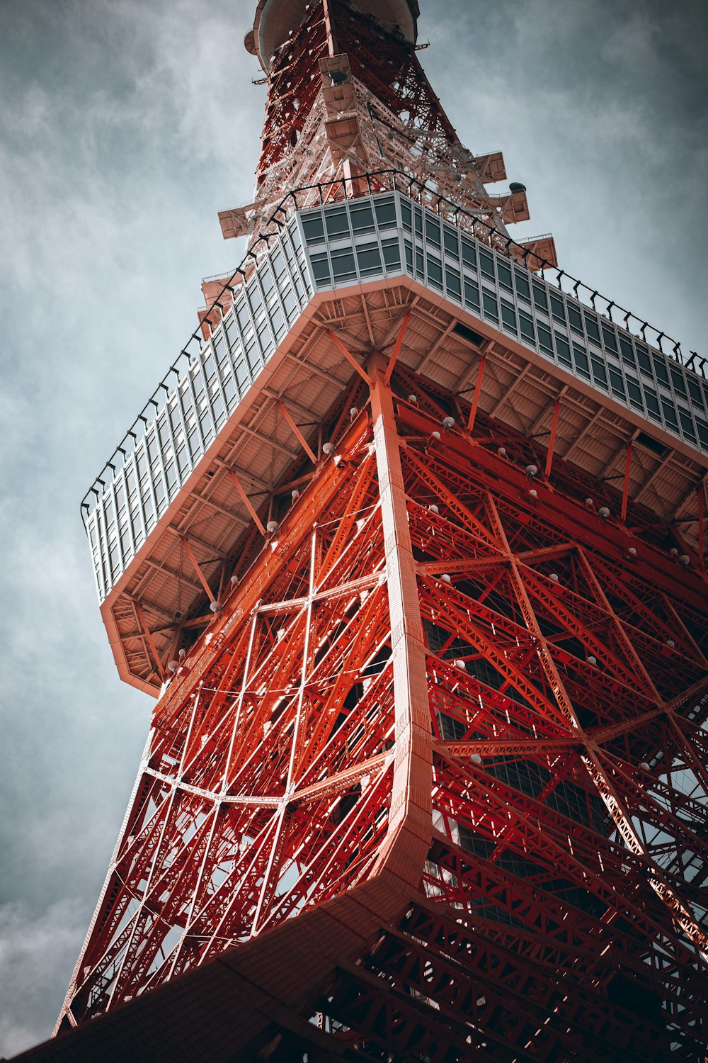 the top of the eiffel tower against a cloudy sky