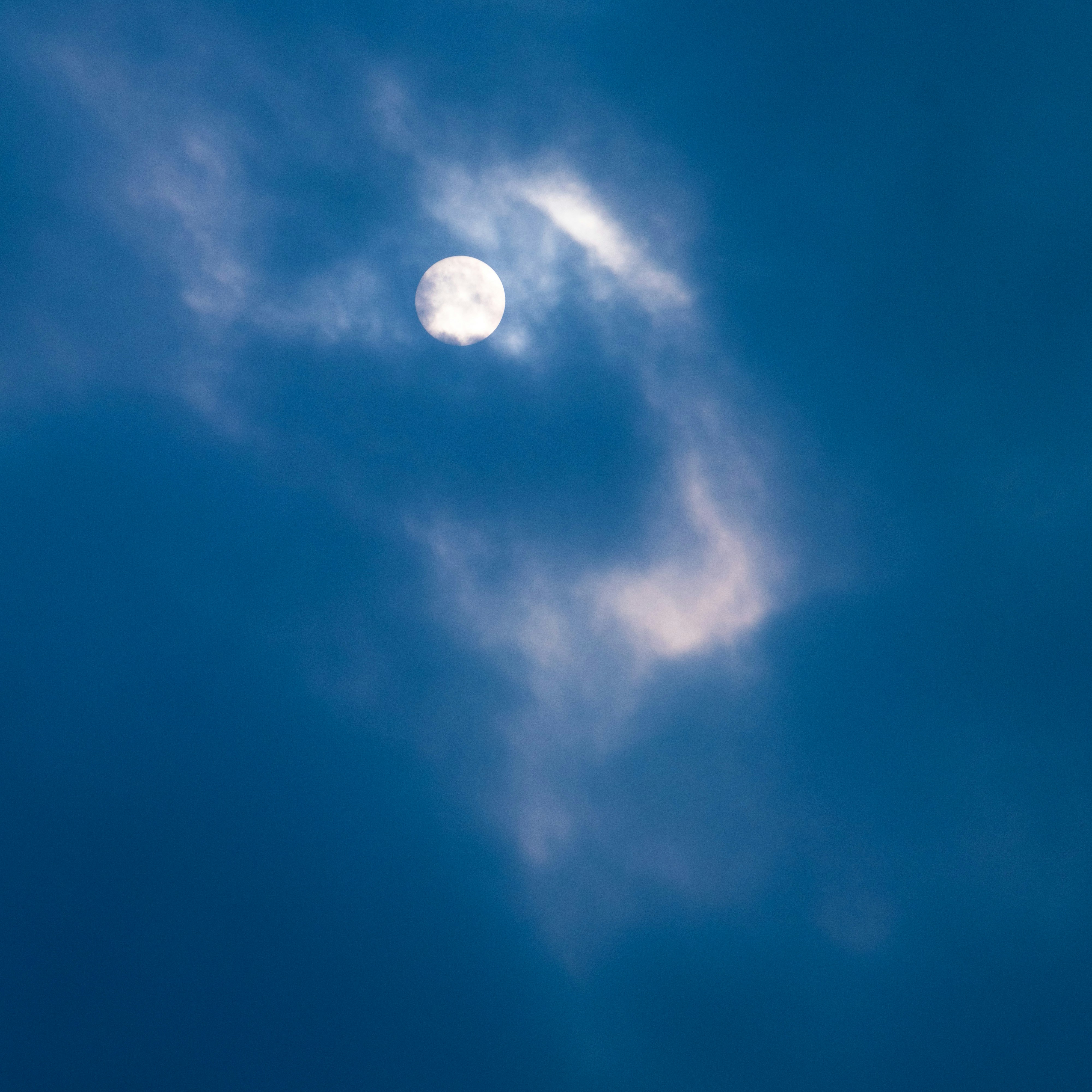 a plane flying in the sky with the moon in the background