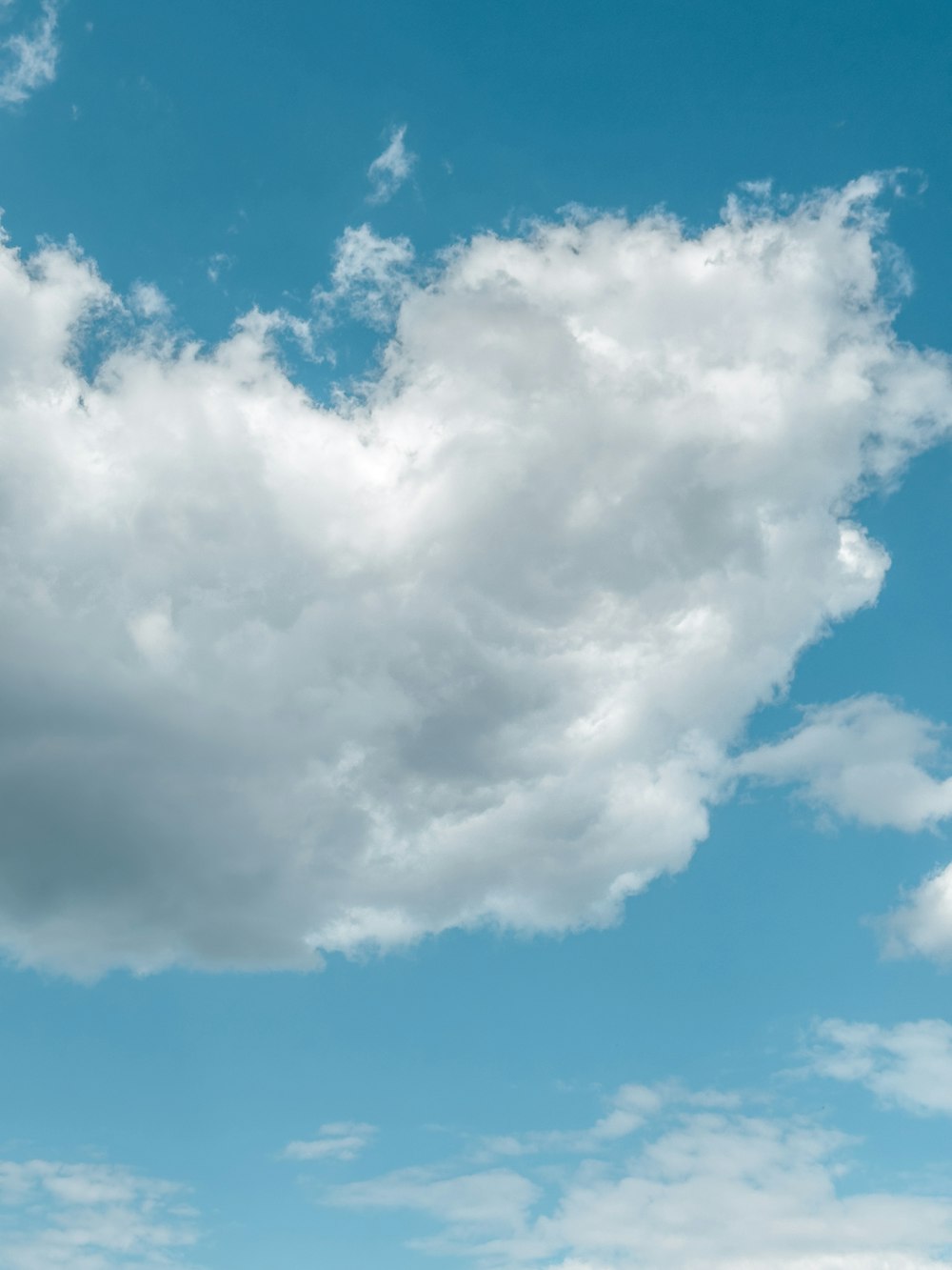 a large white cloud in the blue sky