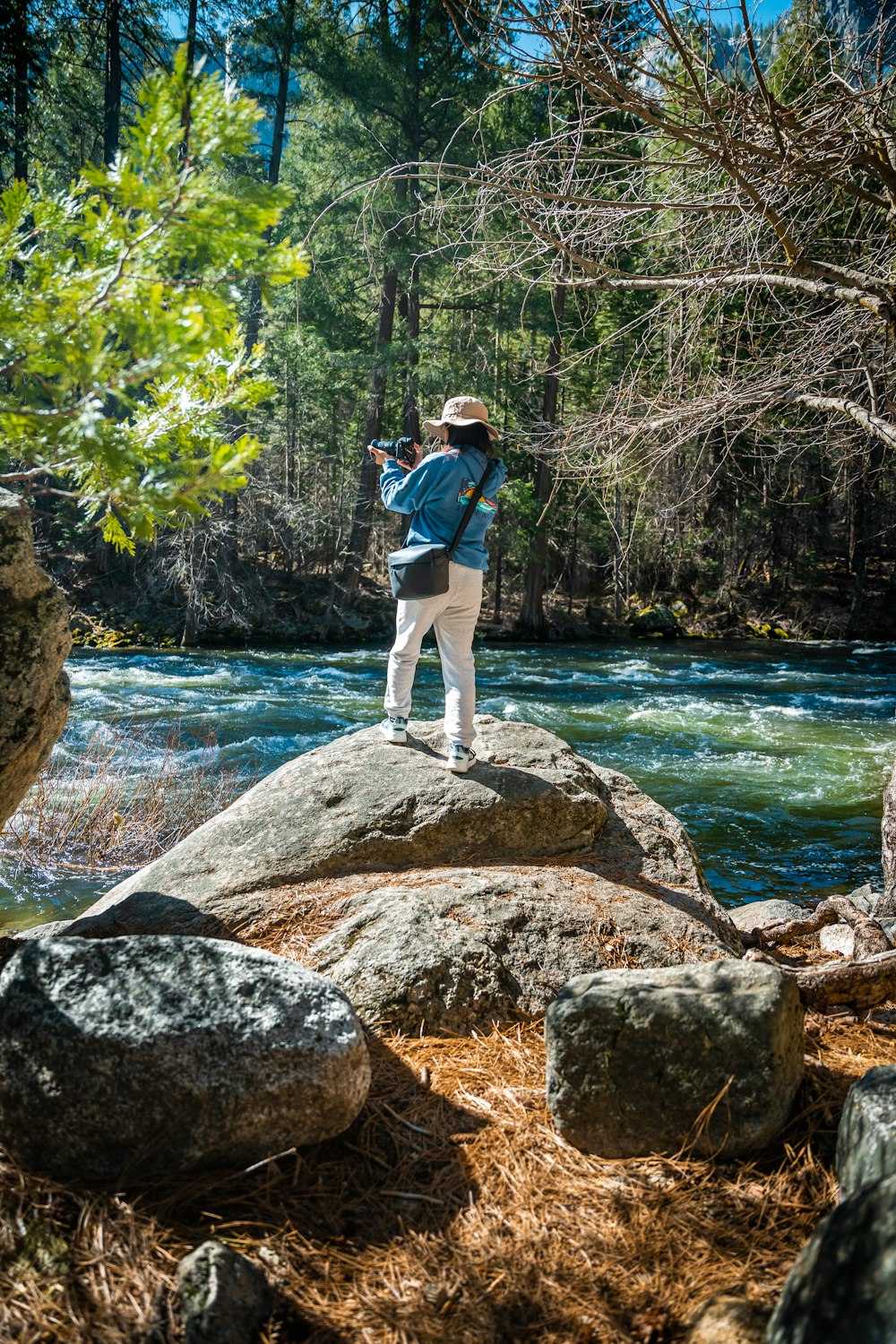 a person standing on a rock in the middle of a river