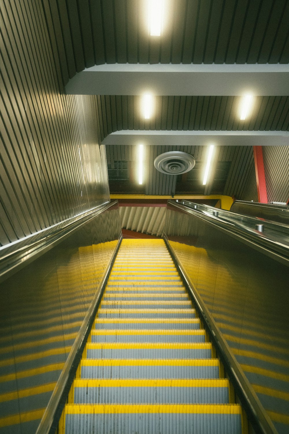 an escalator in a subway station with yellow steps